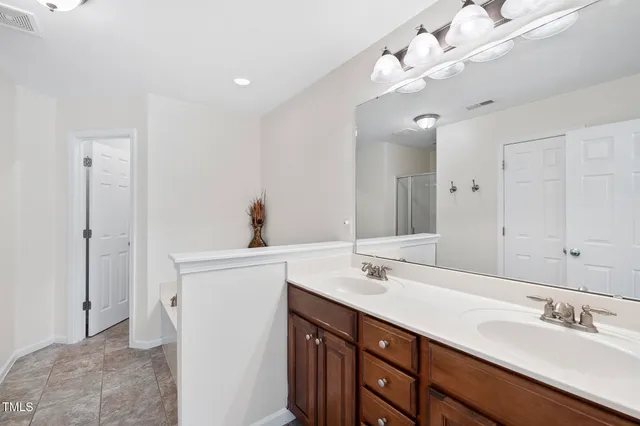 a spacious bathroom with a double vanity sink and a mirror