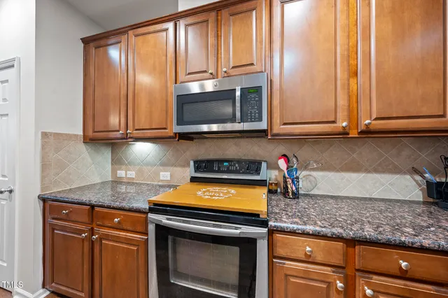 a kitchen with granite countertop cabinets stainless steel appliances and a sink