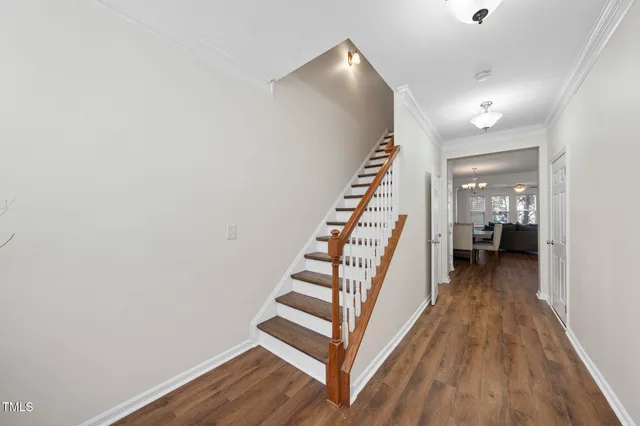 a view of a hallway with wooden floor and staircase