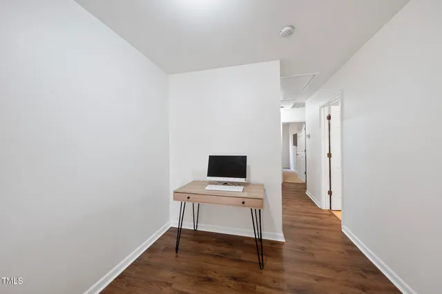 a view of a workspace with furniture and wooden floor