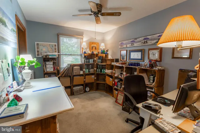 a view of a workspace with furniture and a window