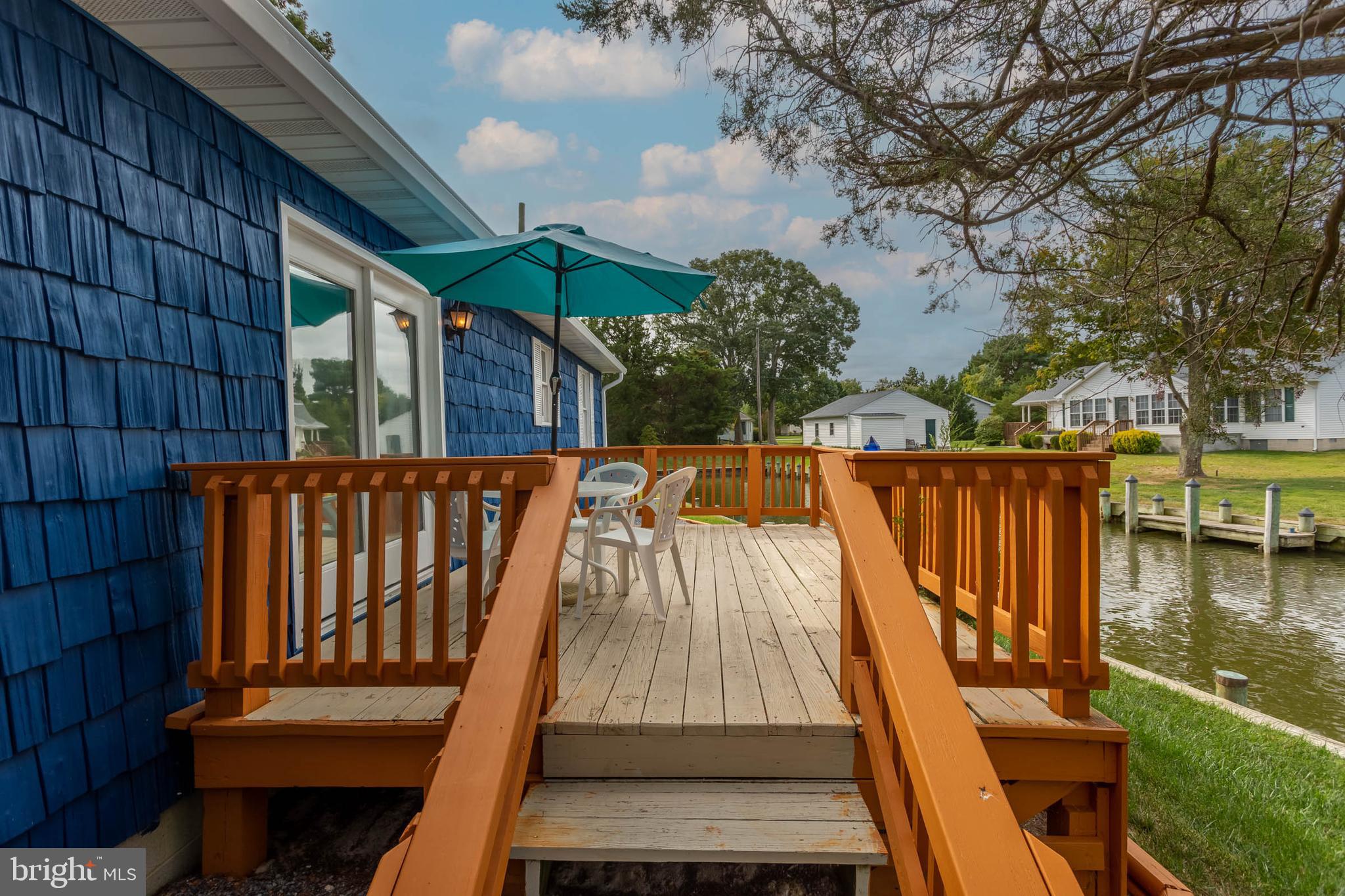 32396 Holly Ter Road Ocean View, DE 19970 - Photo 29 of 42 a balcony with wooden floor and outdoor seating