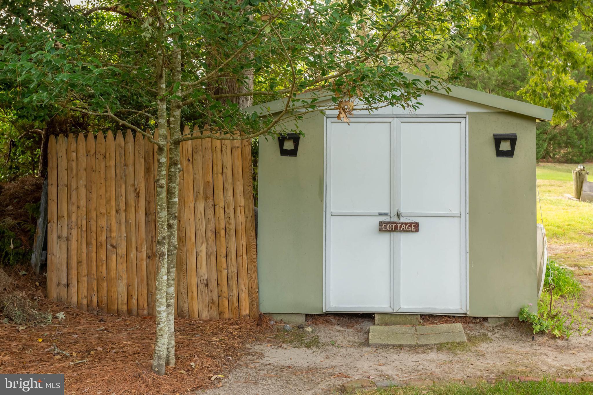 32396 Holly Ter Road Ocean View, DE 19970 - Photo 33 of 42 a view of a backyard with potted plants and wooden fence