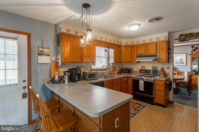 a kitchen with stainless steel appliances granite countertop sink stove top oven and cabinets