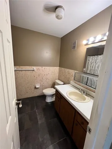 a bathroom with a granite countertop sink a mirror and a toilet