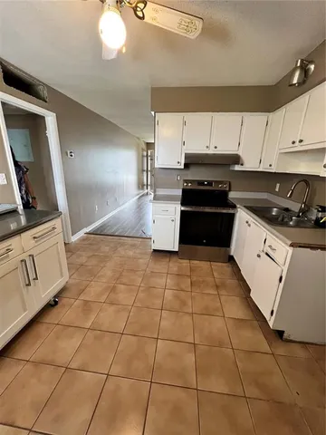 a kitchen with granite countertop a stove a sink and a microwave