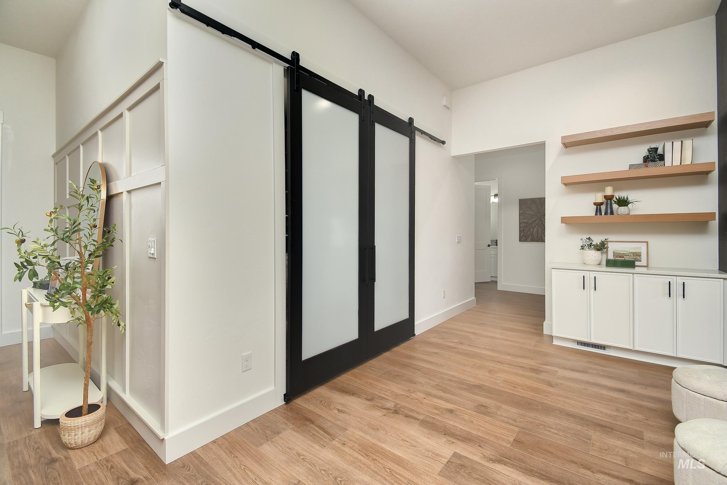 8991 Edna Lane Middleton, ID 83644 - Photo 12 of 50 Corridor with a barn door and light wood-style flooring