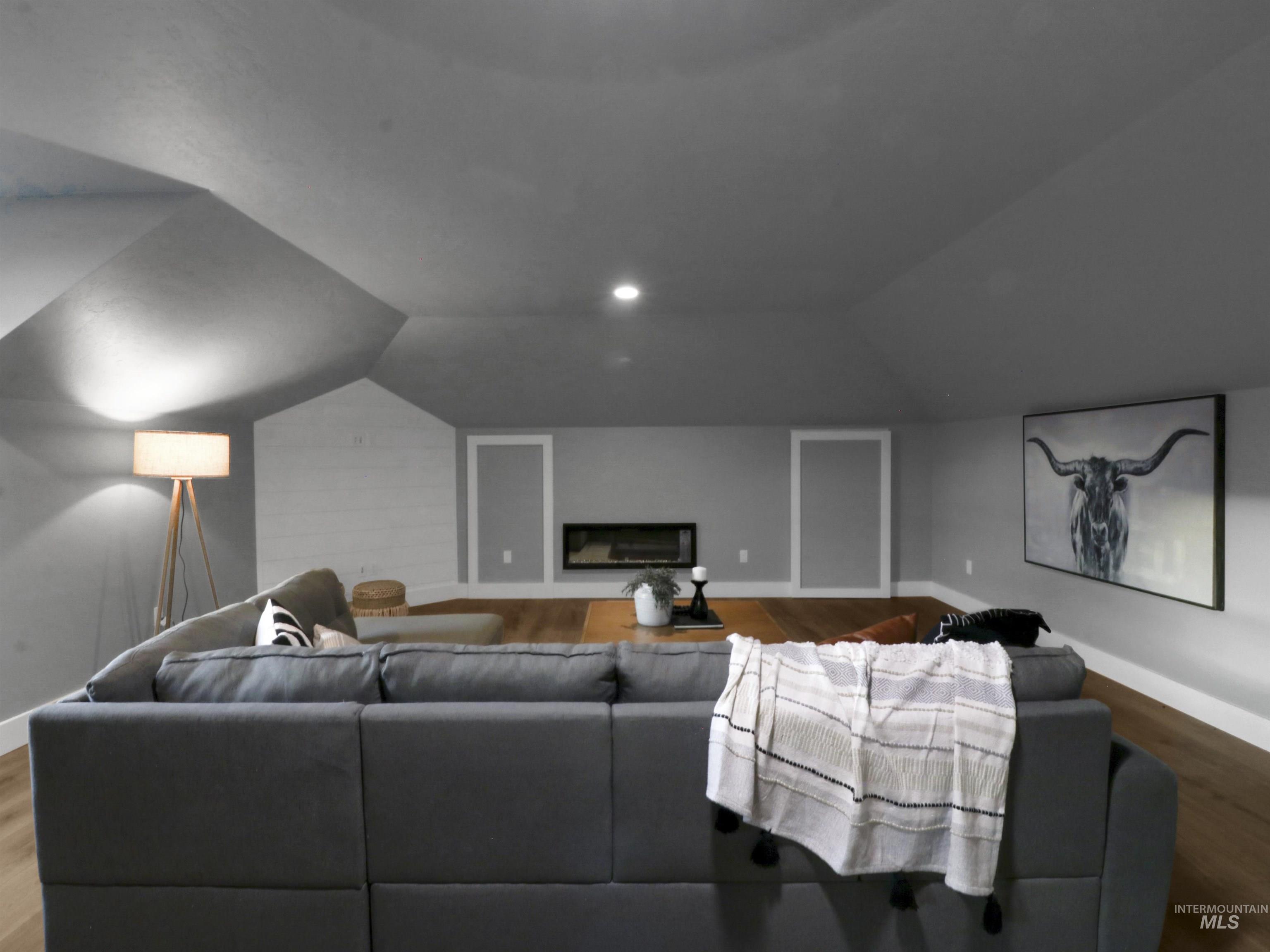 8991 Edna Lane Middleton, ID 83644 - Photo 27 of 50 Cinema room featuring wood finished floors, lofted ceiling, and a glass covered fireplace