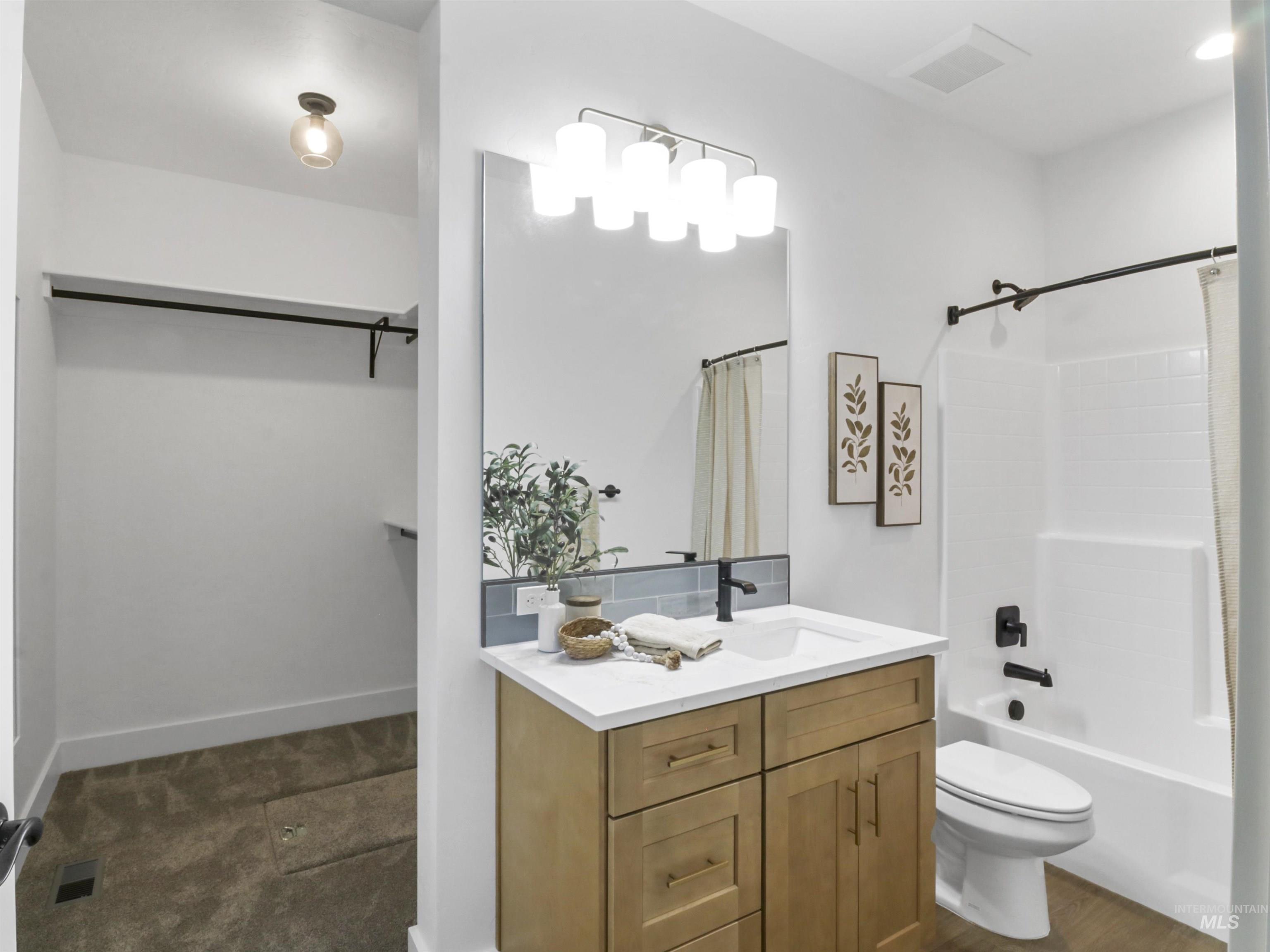 8991 Edna Lane Middleton, ID 83644 - Photo 36 of 50 Bathroom featuring shower / bath combo with shower curtain, vanity, and a spacious closet