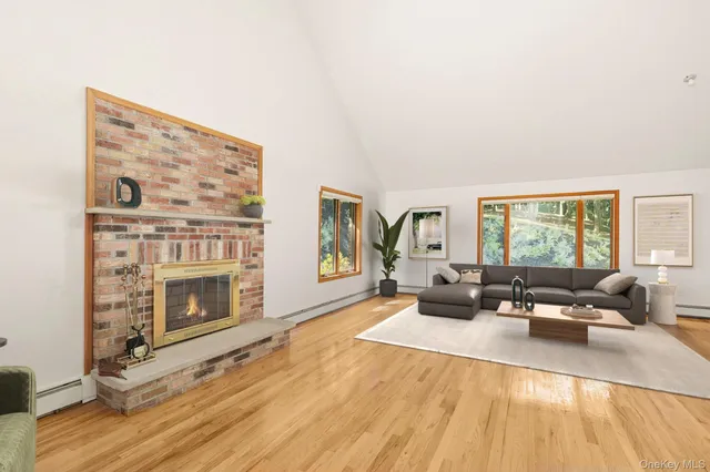 a living room with furniture large window and wooden floor