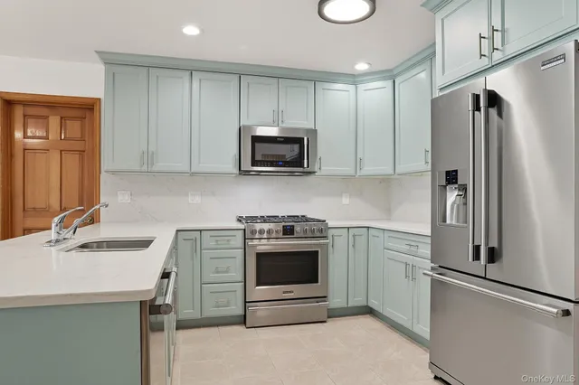 a kitchen with stainless steel appliances granite countertop a stove microwave and refrigerator