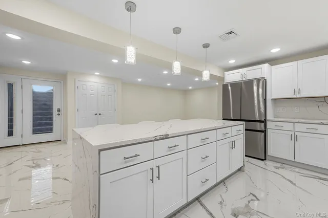 a kitchen with stainless steel appliances granite countertop a refrigerator and a stove top oven