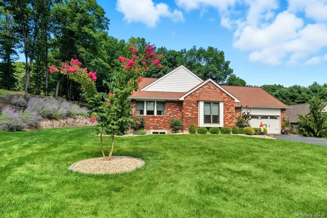 a front view of a house with a yard and trees