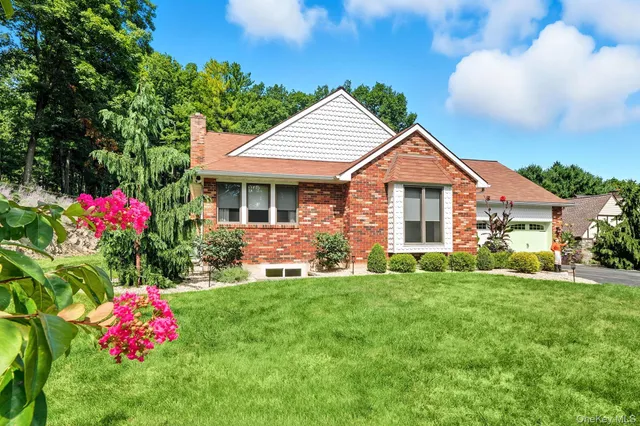 a front view of a house with a big yard and potted plants