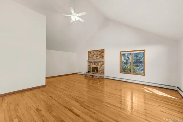 an empty room with wooden floor and window