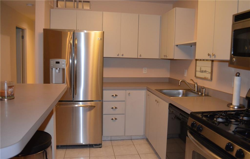 Kitchen with breakfast bar, all stainless steel appliances.