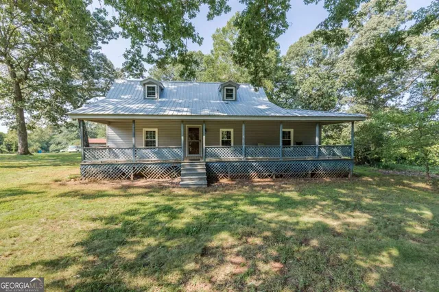a view of a house with backyard and sitting area