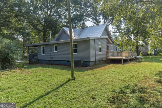 a view of a house with a backyard and a tree