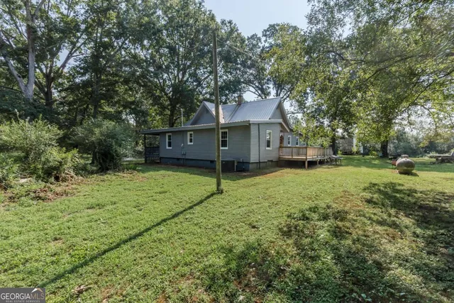 a view of a house with a yard and deck