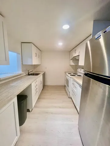 a kitchen with stainless steel appliances granite countertop a refrigerator and a stove top oven