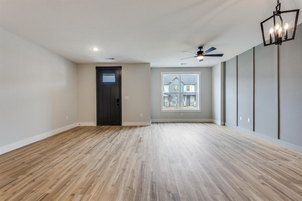 1610 Palladio Loop Princeton, TX 75407 - Photo 2 of 20 an empty room with wooden floor chandelier and windows