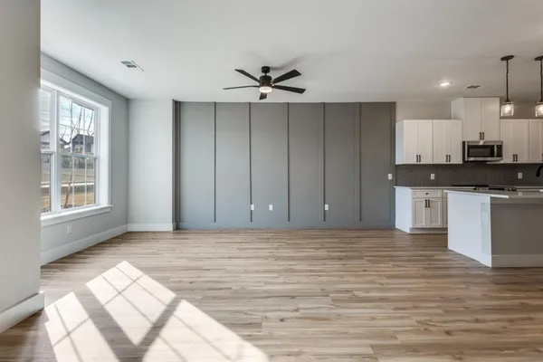 a view of kitchen with granite countertop cabinets and window