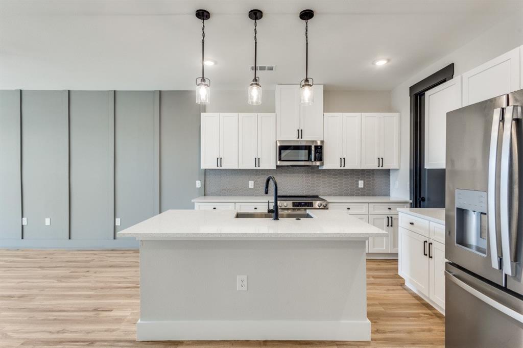 1610 Palladio Loop Princeton, TX 75407 - Photo 4 of 20 a kitchen with stainless steel appliances sink refrigerator and microwave