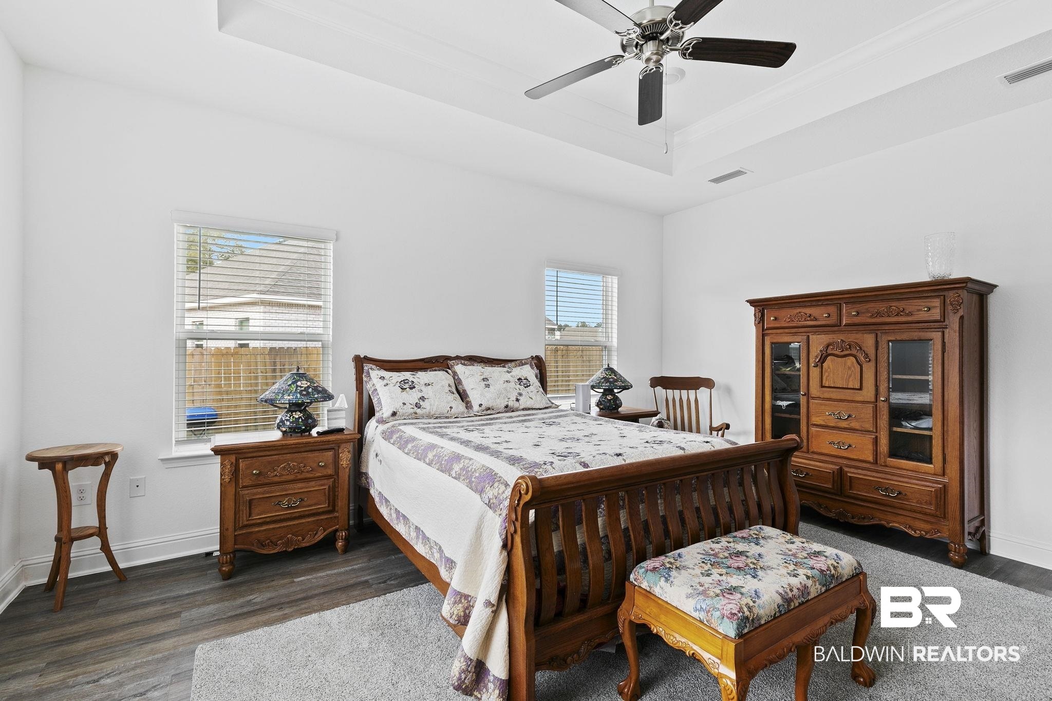 1141 Pencarro Boulevard Foley, AL 36535 - Photo 29 of 70 Bedroom featuring ceiling fan, a tray ceiling, and dark hardwood / wood-style flooring