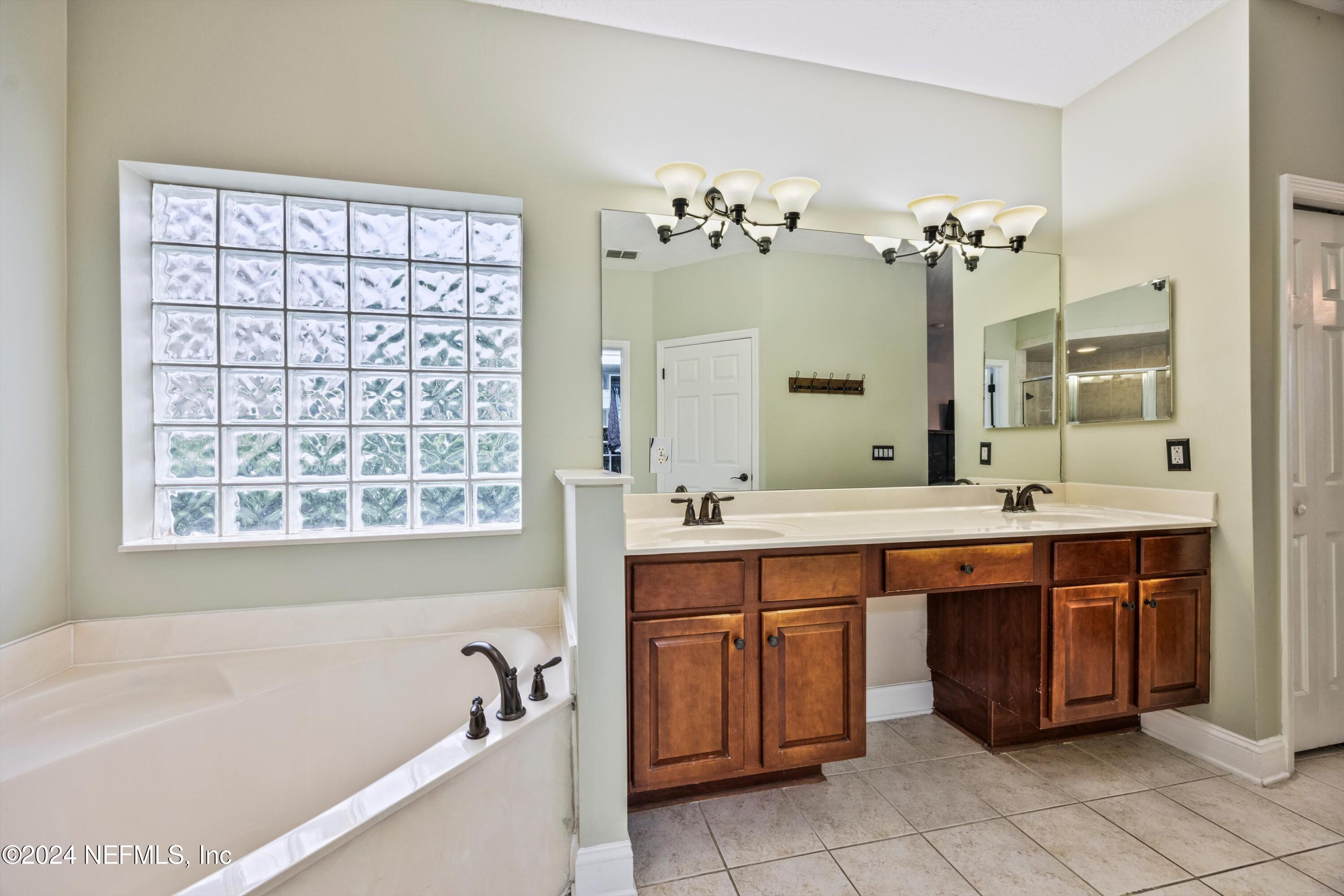 1843 South Landguard Road St. Augustine, FL 32092 - Photo 19 of 67 a spacious bathroom with a double vanity sink large mirror and a bathtub