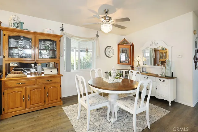 a dining room with wooden floor and chandelier