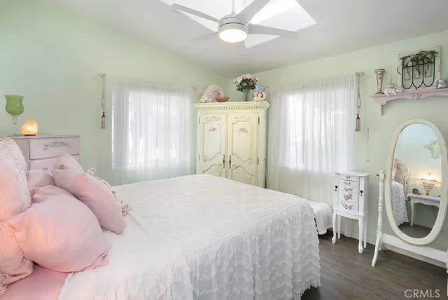 a bedroom with a bed a chandelier and dresser