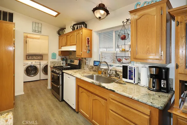 a kitchen with stainless steel appliances granite countertop a sink a stove and a refrigerator