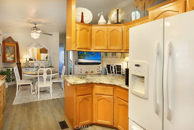 a kitchen with stainless steel appliances granite countertop wooden cabinets a dining table and chairs