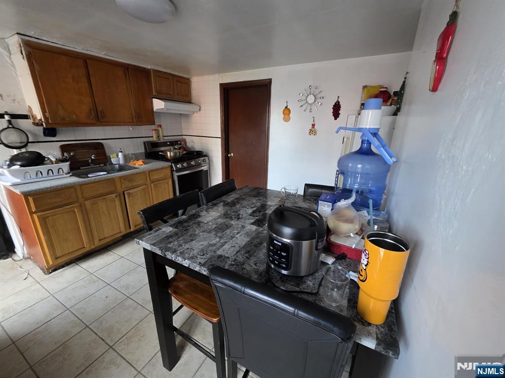 32 Elm Street Paterson, NJ 07501 - Photo 3 of 20 a kitchen with a stove and a refrigerator