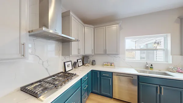 a kitchen with refrigerator and white cabinets