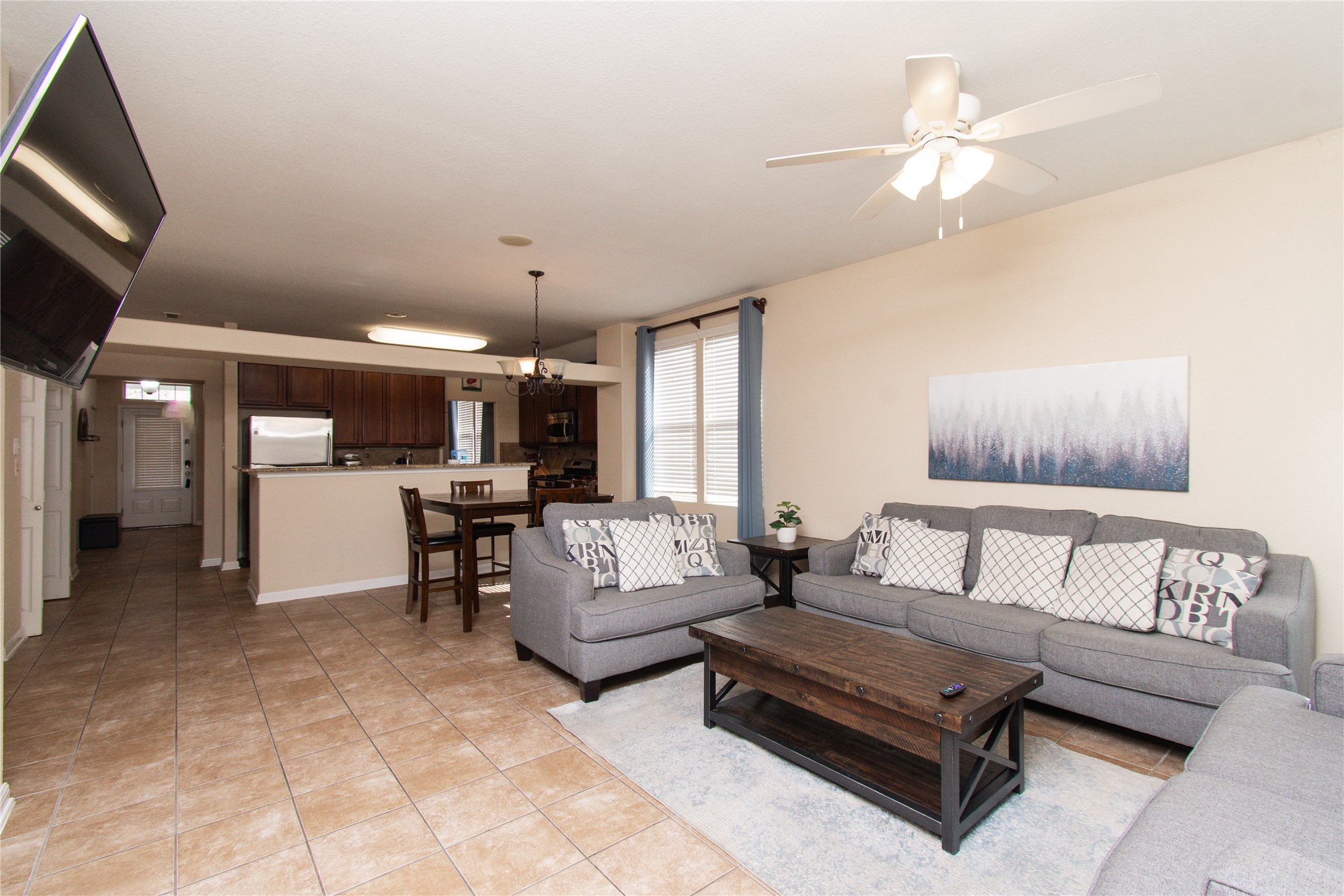 421 Shadow Point San Marcos, TX 78666 - Photo 6 of 24 Living room featuring a ceiling fan, light tile patterned flooring, and suspended lighting