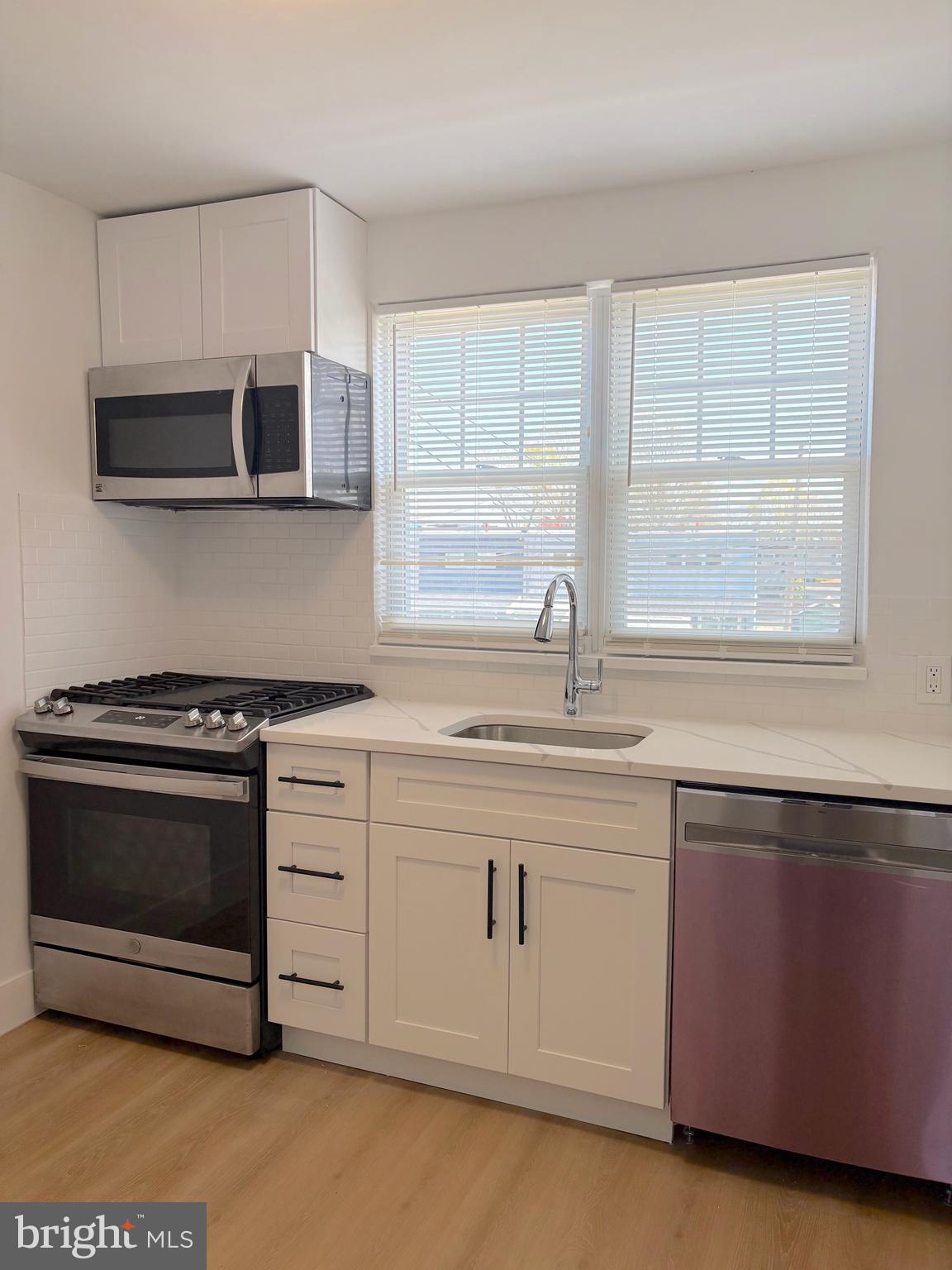 12157 Aster Road Philadelphia, PA 19154 - Photo 2 of 6 a kitchen with stainless steel appliances white cabinets and a stove top oven