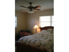 1776 North Dodge Melbourne, FL 32935 - Photo 4 of 6 a bedroom with a bed and a chandelier
