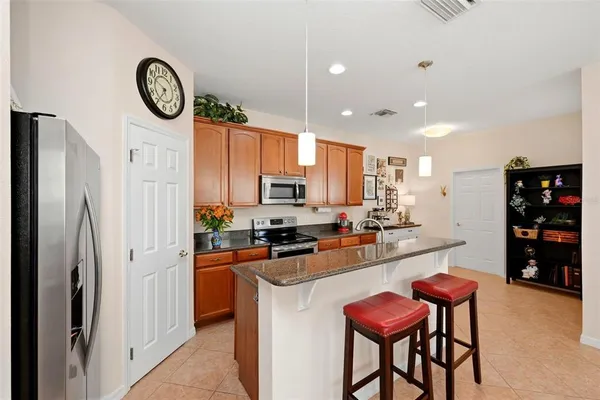 a kitchen with stainless steel appliances granite countertop a stove refrigerator a sink dishwasher with a dining table and chairs