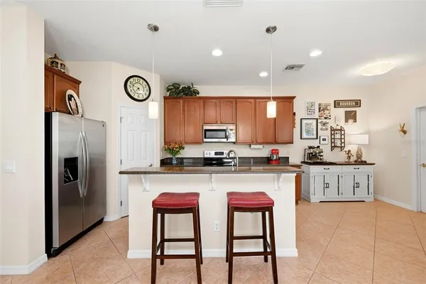 a kitchen with stainless steel appliances granite countertop a sink a stove and a microwave