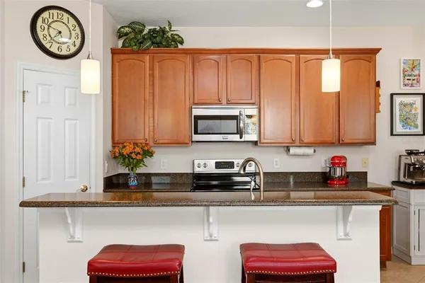 a kitchen with stainless steel appliances a stove top oven a sink dishwasher and cabinets with wooden floor