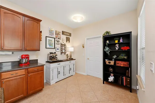 a living room with furniture kitchen area and a window