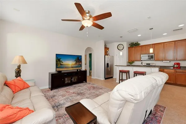 a living room with furniture a flat screen tv and a window