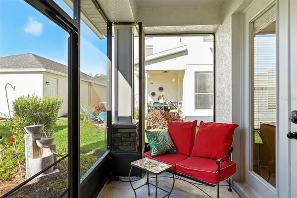 a view of a porch with furniture and floor to ceiling window