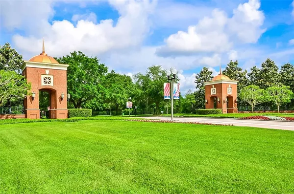 a front view of a house with a yard and fountain in middle