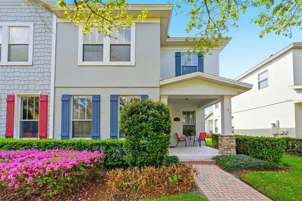 a front view of house and yard with beautiful flowers