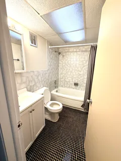 a bathroom with a sink a toilet a window and shower
