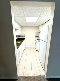 a kitchen with white cabinets and white appliances