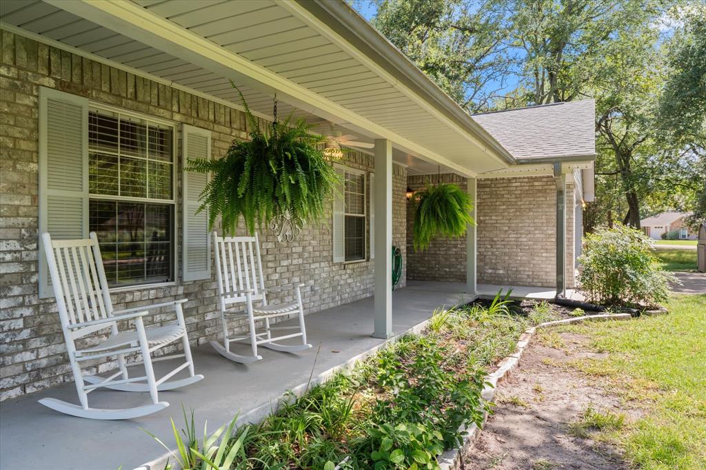 116 Meadowood Road Enchanted Oaks, TX 75156 - Photo 4 of 37 Brick exterior with a covered front porch, featuring a gray concrete surface, light-colored brick facade, and gray louvered shutters