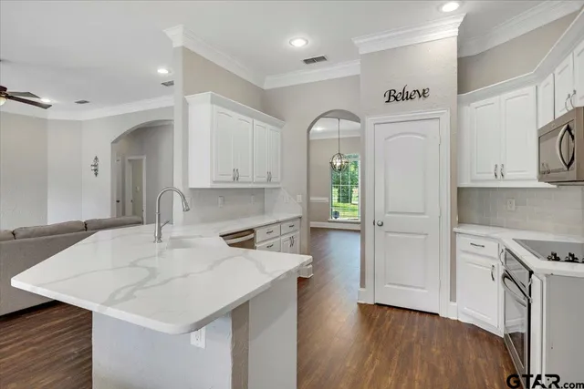 a kitchen with cabinets and wooden floor